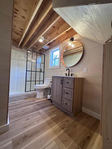 a bathroom with a sink and a toilet and a mirror at Modern Tiny Barn Urban Oasis in San Antonio in San Antonio