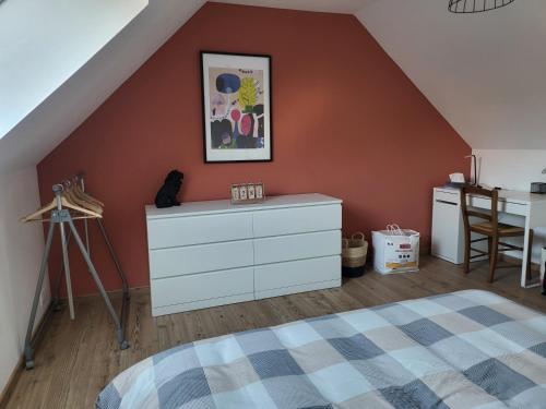 a bedroom with a bed and a dresser in a attic at Le terracotta in La Vernelle