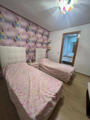 a bedroom with two beds and a pink wall at Beach appartement in Kenitra