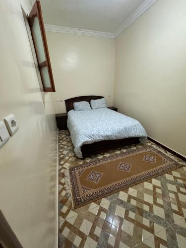 une chambre avec un lit et un tapis au sol dans l'établissement appartement traditionnel, à Taghazout