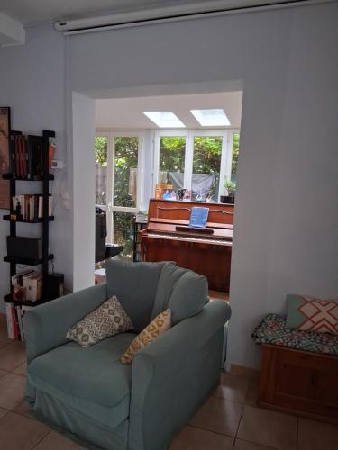 a living room with a couch and a piano at Escale fleurie in Toulouse