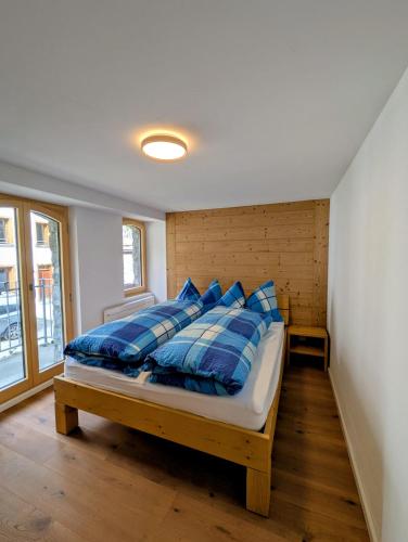 a bedroom with a bed with blue and white pillows at Ferienwohnung Rosenburg in Randa