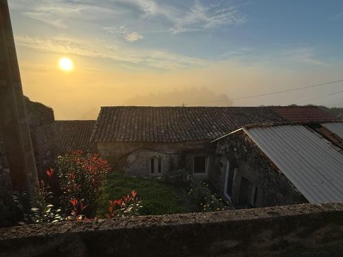 an old house with the sunset in the background at Mirada Do Roxo in Oia