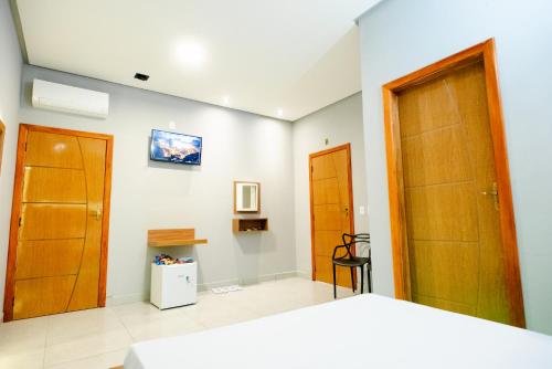 a bedroom with a bed and two wooden doors at Pousada Malibu in Vitória da Conquista