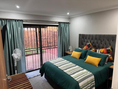 a bedroom with a bed and a large window at ORT Tranquil Stay in Boksburg
