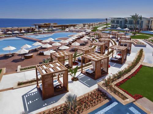 an aerial view of a resort with a pool and umbrellas at Rixos Premium Magawish Suites and Villas- Ultra All-Inclusive in Hurghada