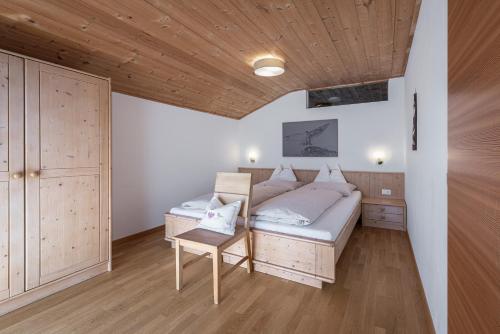 Un dormitorio con una cama y un techo de madera. en Schopplhof - panoramic apartments dolomites, en Villnoss