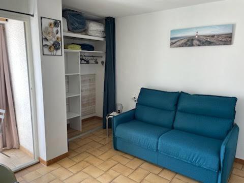 a living room with a blue couch in a room at Studio Emilie in Balaruc-les-Bains