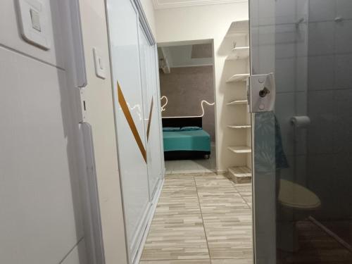 a room with a hallway with a room with a bed at Edícula aconchegante em Peruíbe in Peruíbe