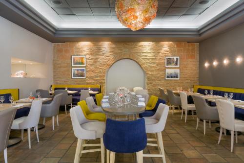 a dining room with tables and chairs and a chandelier at Abbaye des Capucins Spa & Resort in Montauban