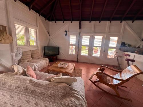 una sala de estar con un sofá y una mesa en Villa Magalante, sea view, en Grand-Bourg