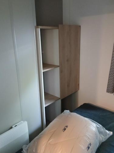 a bedroom with a bed and a book shelf at Charmant mobil-home 244 in Narbonne