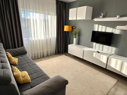 un salon avec un canapé et une télévision dans l'établissement Central Vibe, à Curtea de Argeş