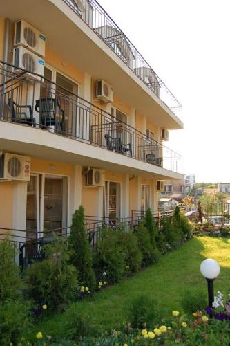 a building with balconies and tables and chairs on it at Family Hotel Dayana Beach in Sinemorets