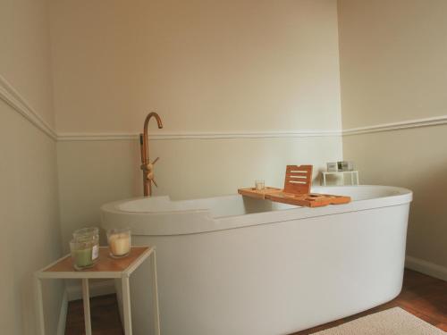 a white bathroom with a sink and a table at Maison Pistache in Le Dorat
