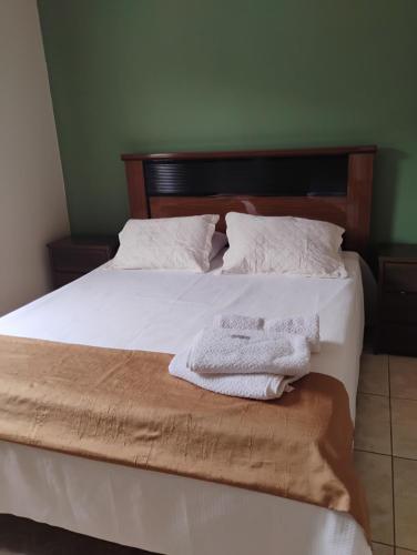 a bedroom with a bed with two towels on it at Top House in Espirito Santo Do Pinhal