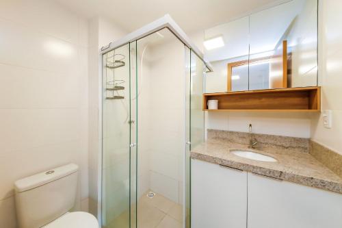 a bathroom with a toilet and a glass shower at Studio 404 On São Mateus in Juiz de Fora