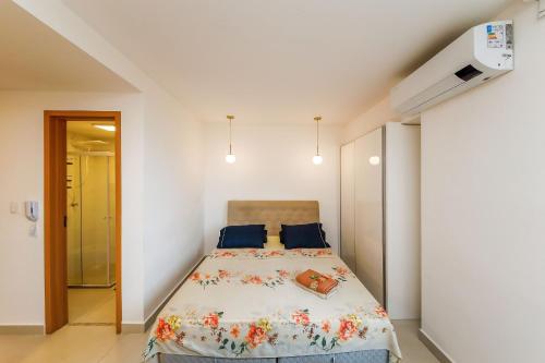 a bedroom with a large bed with blue pillows at Studio 404 On São Mateus in Juiz de Fora