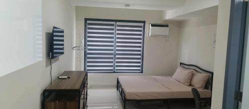 マンダウエ・シティにあるLei's Abodeのベッドと窓のある小さな部屋