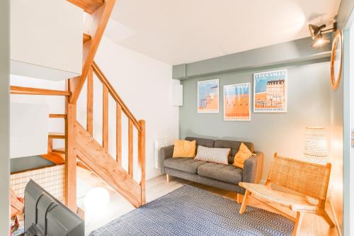 a living room with a couch and a staircase at Appartement d'Antonin - 50m de la plage in Trouville-sur-Mer