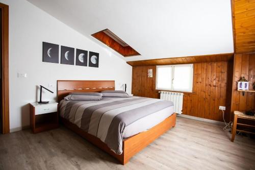 Un dormitorio con una cama grande con paredes de madera. en Casa Liscidini, en Aprica