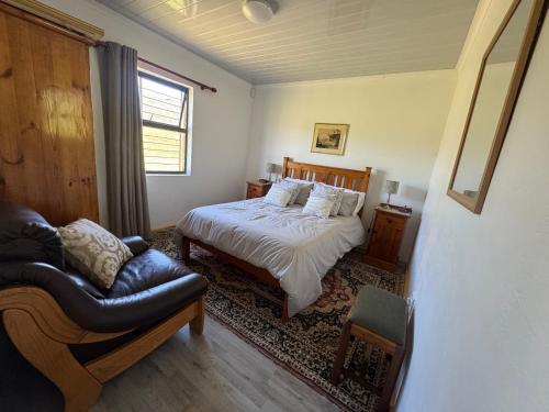 a bedroom with a bed and a couch and a chair at Tulbagh Tiny Homes in Tulbagh