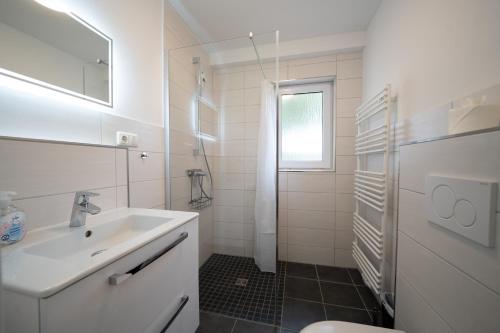 a white bathroom with a sink and a toilet at Haus Sonnenwinkel Ina in Dahme