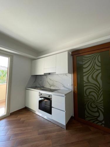 une cuisine avec des armoires blanches et une cuisinière dans l'établissement Case Vacanze Naiade e Nereide, à Reggio de Calabre