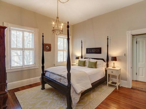 a bedroom with a bed and a chandelier at Luxury on Lincoln in Savannah