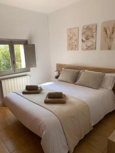 a large white bed with two towels on top of it at Apartament La Plana in Campdevánol