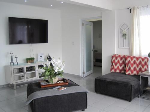 a living room with a couch and a tv at Casa Fortuna Near Luquillo Beach & El Yunque in Luquillo