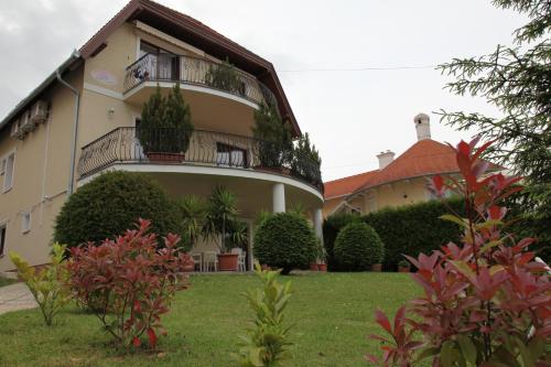 a building with a balcony on the side of it at Erika Apartmanházak in Hévíz