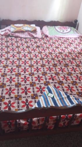 a bed with a quilt on top of it at New royal home stay in Varkala