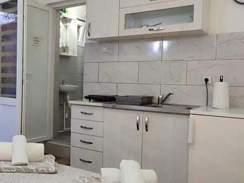 a white kitchen with a sink and a counter at Olgica lux in Pojate