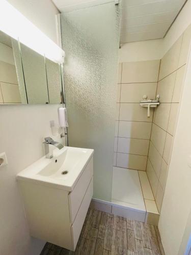 a white bathroom with a sink and a shower at Ferienhaus am Bächle in Breitnau