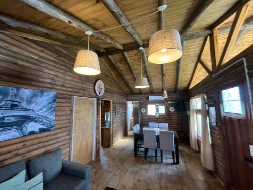 uma sala com paredes de madeira, uma mesa e luzes em Cabañas Don Camilo em Tandil