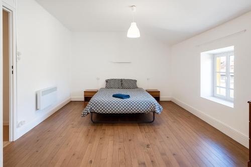 a bedroom with a bed in the middle of a room at Appartement 2 chambres avec baignoire Lavelanet in Lavelanet