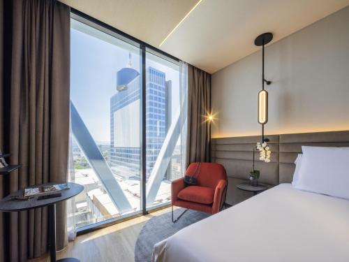 a hotel room with a bed and a chair and a window at Novotel Mexico City World Trade Center in Mexico City