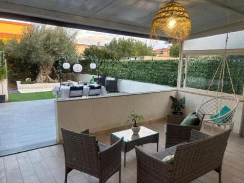 a patio with a swing and chairs and a table at Maria Apartment in Vaccarizzo - Delfino