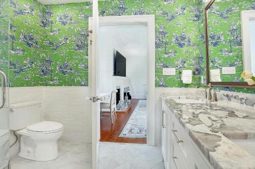 a bathroom with a toilet and a sink and a tv at 3 W Perry St in Savannah