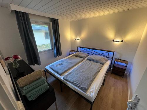 a small bedroom with a bed and a window at Feriendorf Seddiner See - Bungalow 8 in Seddin
