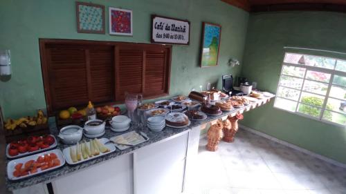 a buffet with many different types of food on a counter at Pousada Pé da Mata in Aiuruoca