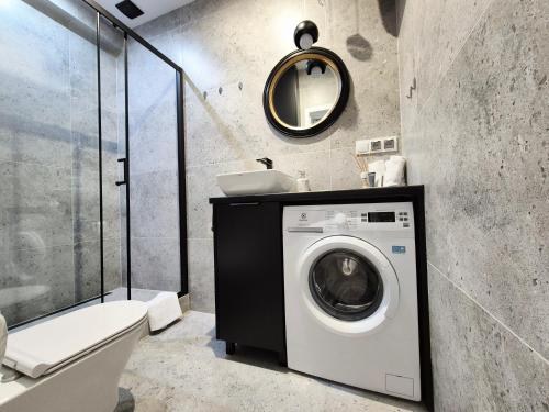 a bathroom with a washing machine and a sink at Apartament Diamond in Częstochowa