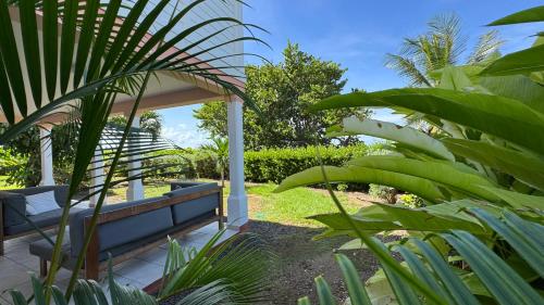 a bench in the middle of a garden at Malora Beach in Le Moule