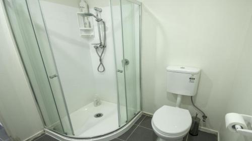 a bathroom with a shower and a toilet at Beautiful and Bright Studio Apartment Botany Downs in Auckland