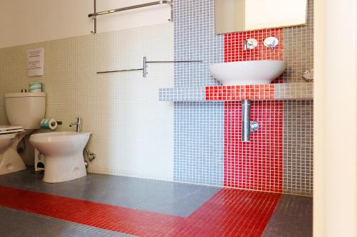 a bathroom with a toilet and a sink at Nuova Mastrarua Rooms in Siracusa