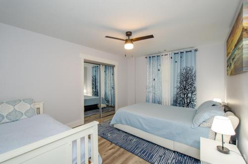 Un dormitorio blanco con dos camas y una ventana. en Cozy Adventure Basement, en Buford