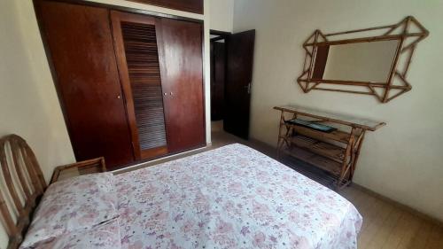 a bedroom with a bed with a dresser and a mirror at Perto do peixe Marley - Praia do Morro in Guarapari