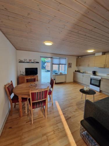 a living room with a table and a kitchen at Lejlighed i Gråsten in Gråsten