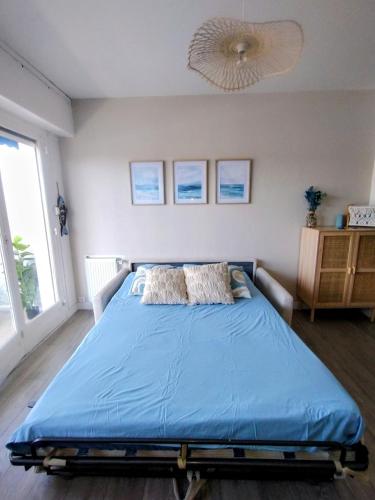 a bedroom with a bed with a blue comforter at Le Galop Bleu in Cagnes-sur-Mer